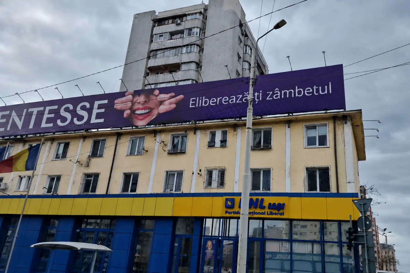 Banner mov pentru servicii dentare, montat pe acoperișul unei clădiri urbane
