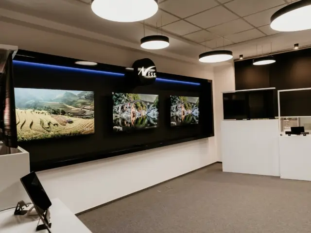 Vedere generală a spațiului NESS cu mobilier custom, media wall și iluminare suspendată