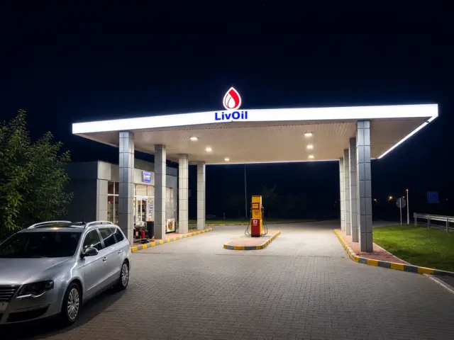 Sigla și numele LivOil iluminate pe copertina unei stații de alimentare, surprinsă noaptea.