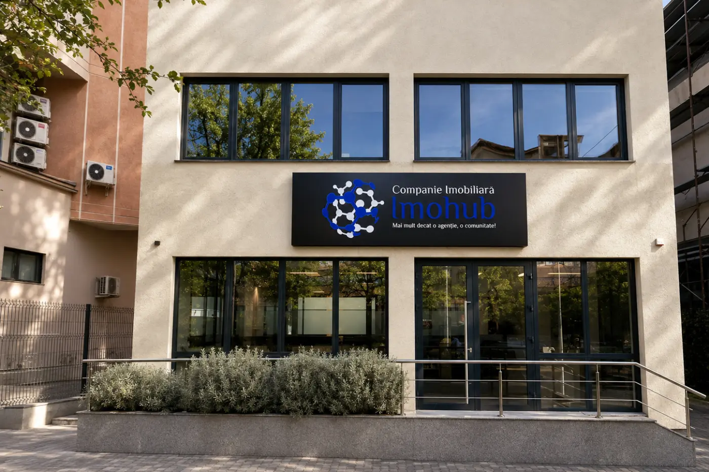 Panou Imohub pentru companie imobiliară, montat pe fațadă deasupra intrării vitrate.