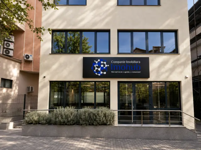 Black Imohub real estate sign mounted on the facade above the glazed entrance.