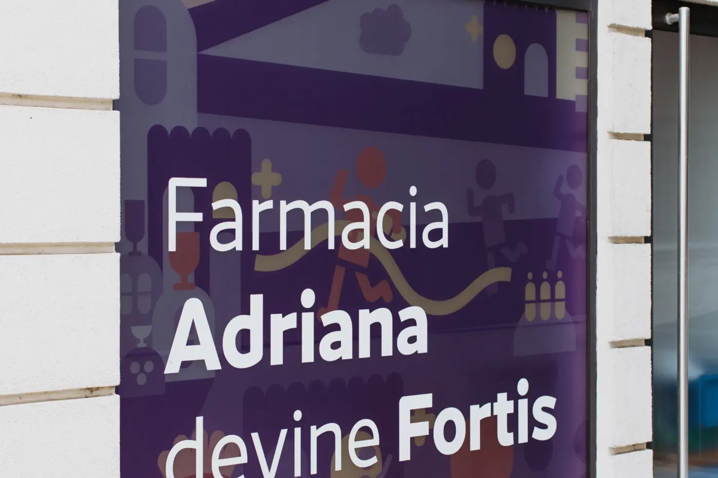 Vitrină arcuită acoperită cu grafică violet ilustrată și mesajul „Farmacia Adriana devine Fortis”.