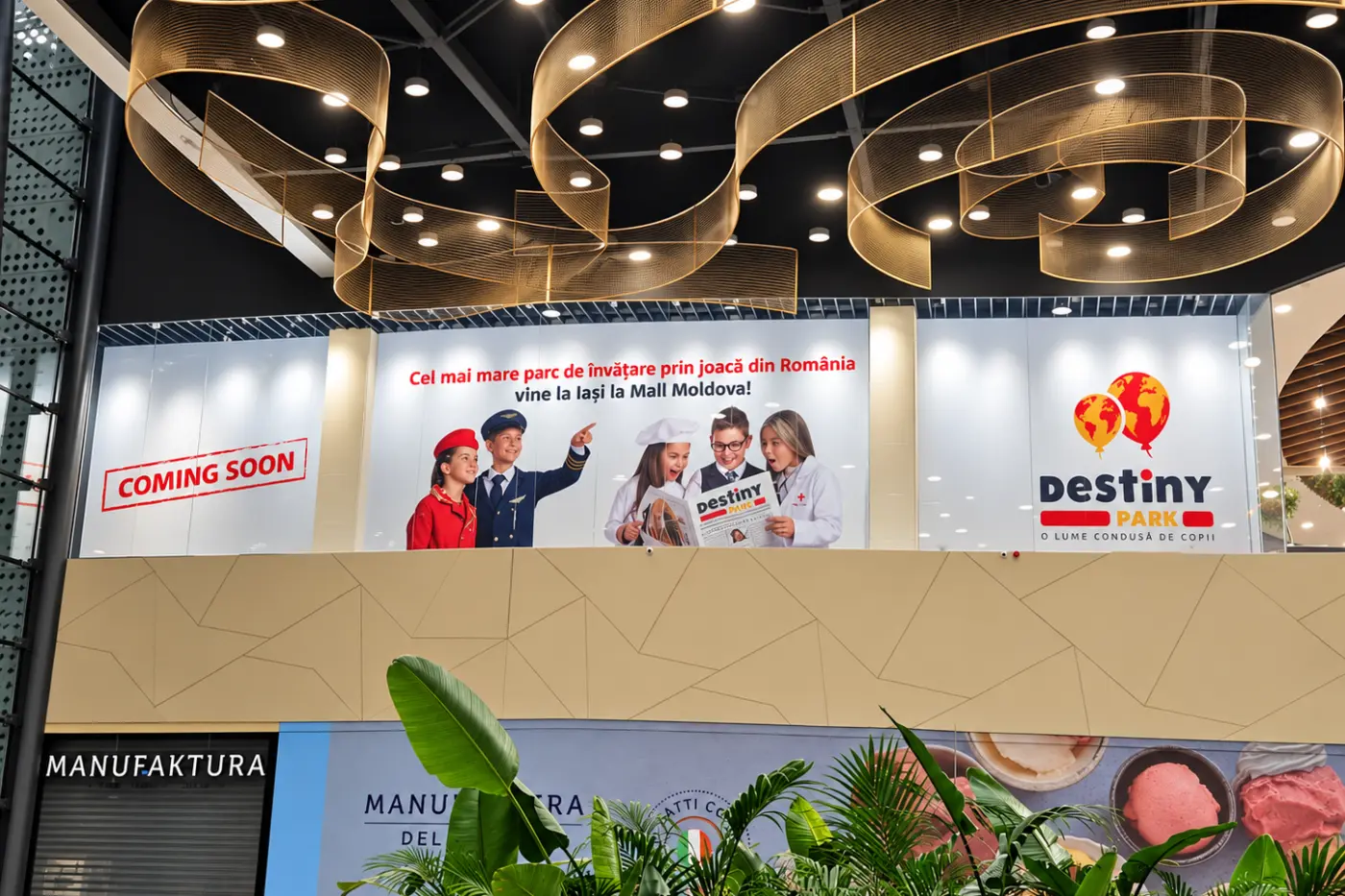 Autocolant Destiny Park pe vitrina unui spațiu comercial, cu copii costumați și mesajul „Coming Soon”