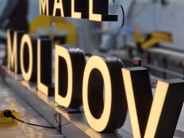 Literele volumetrice MALL MOLDOVA, aprinse și aliniate pe bancul de lucru din atelier.