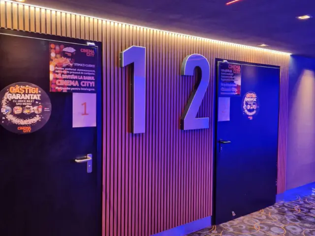 Numere volumetrice 1 și 2 montate între ușile sălilor Cinema City, pe un perete cu lamele.