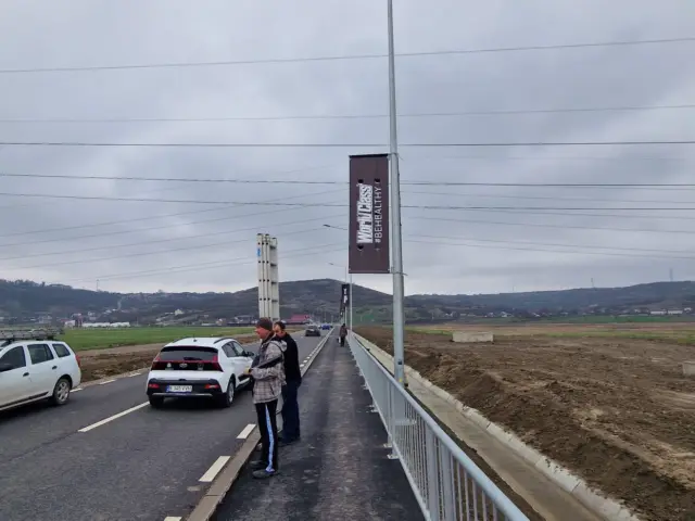 Bannere verticale montate succesiv pe stâlpi, de-a lungul unei șosele cu trafic auto