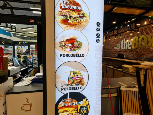 Panou publicitar luminos vertical the BOX, cu preparate din meniu, amplasat la intrarea în restaurant.