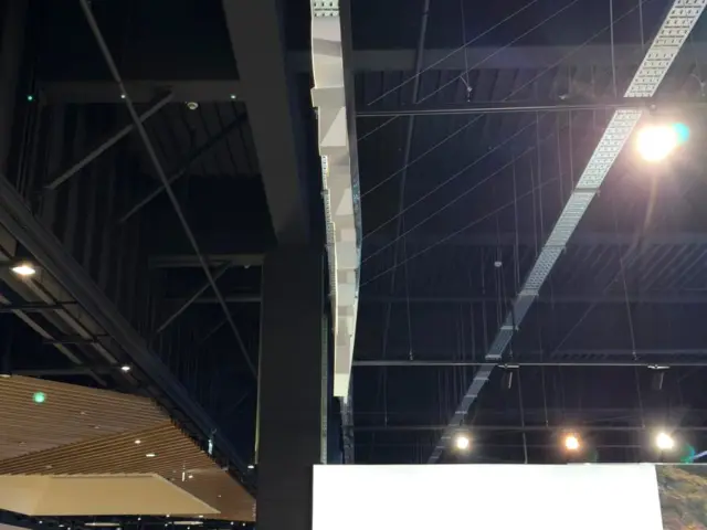 Panou publicitar luminos de mari dimensiuni, cu un automobil albastru, instalat într-un spațiu comercial.