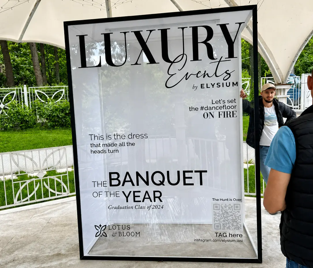 Fotobox personalizat Luxury Events by Elysium, cu ramă neagră și panou transparent, instalat sub un pavilion.