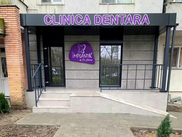 Litere volumetrice „CLINICA DENTARĂ” și sigla Implantik montate pe fațada intrării.