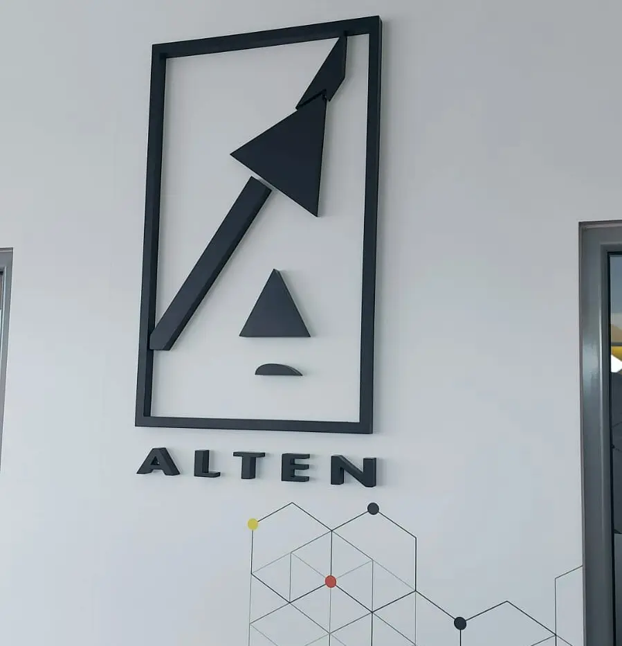 Logo-ul și literele volumetrice ALTEN, montate pe un perete cu decor geometric într-un birou.