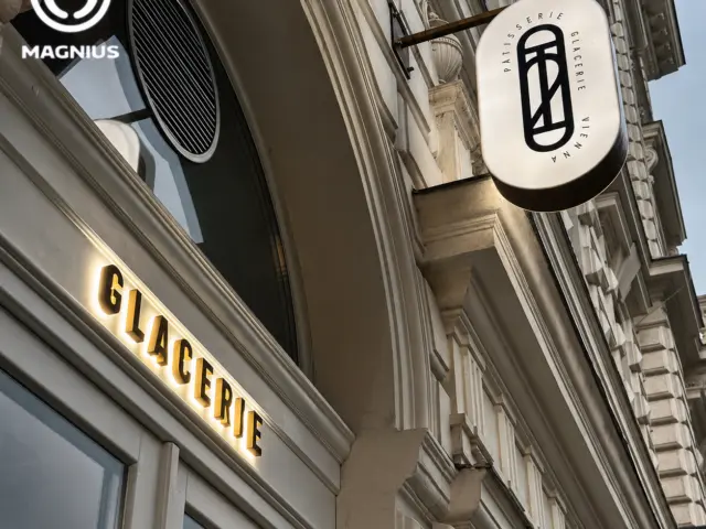 Însemn Vienna cu casetă luminoasă perpendiculară și litere GLACERIE iluminate pe fațadă.