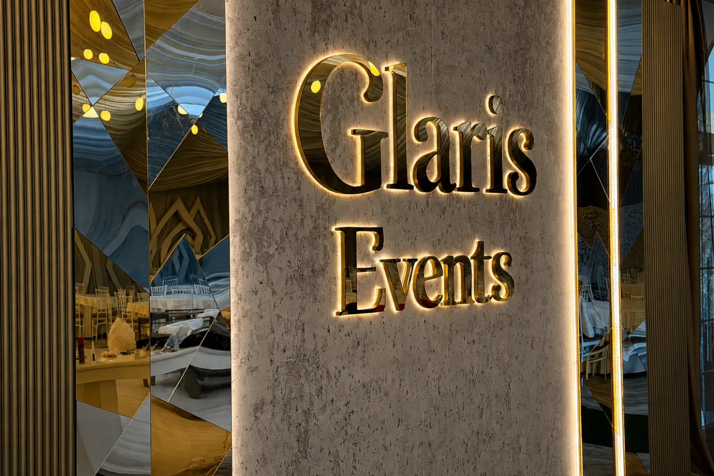 Însemnul Glaris Events cu litere reflectante iluminate din spate, montat între panouri decorative cu oglinzi.