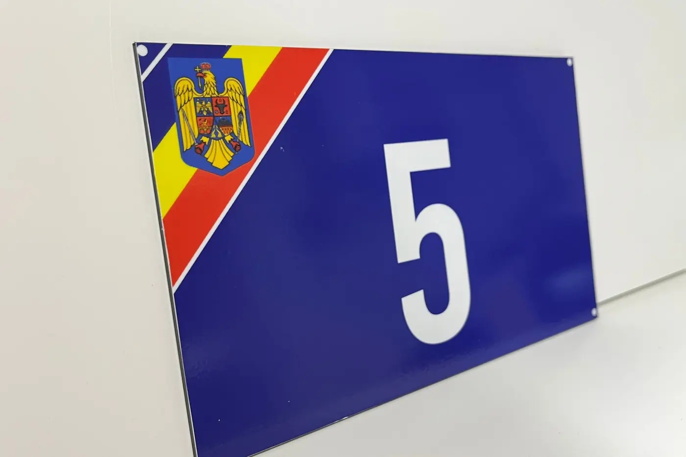 Plăcuță albastră pentru locuință, cu numărul 5, stema României și detalii tricolore.