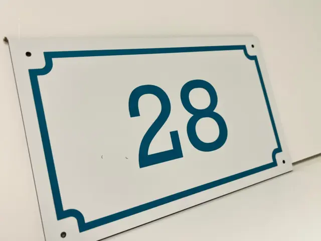 Plăcuță albă pentru numărul 28, cu cifre turcoaz, chenar decorativ și găuri de montaj.