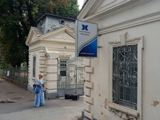 Firmă luminoasă dreptunghiulară, cu două fețe, montată perpendicular pe fațada Liceului Varlaam Mitropolitul.