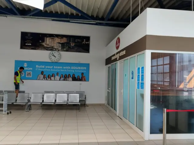 Panou publicitar orizontal EBUROM pentru recrutare, montat deasupra scaunelor dintr-un terminal aeroportuar.
