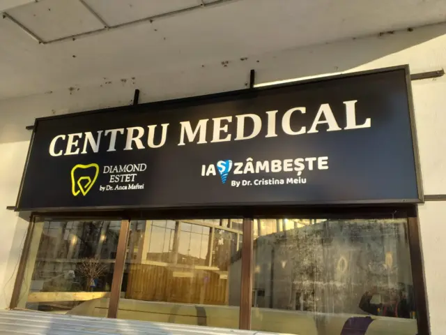 Firmă luminoasă neagră deasupra vitrinei, inscripționată Centru Medical, Diamond Estet și Ia Zâmbește.