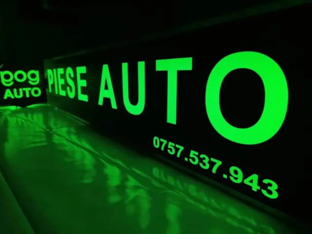 Firmă luminoasă EOG Auto pentru piese auto, cu text verde și număr de telefon pe fundal negru.