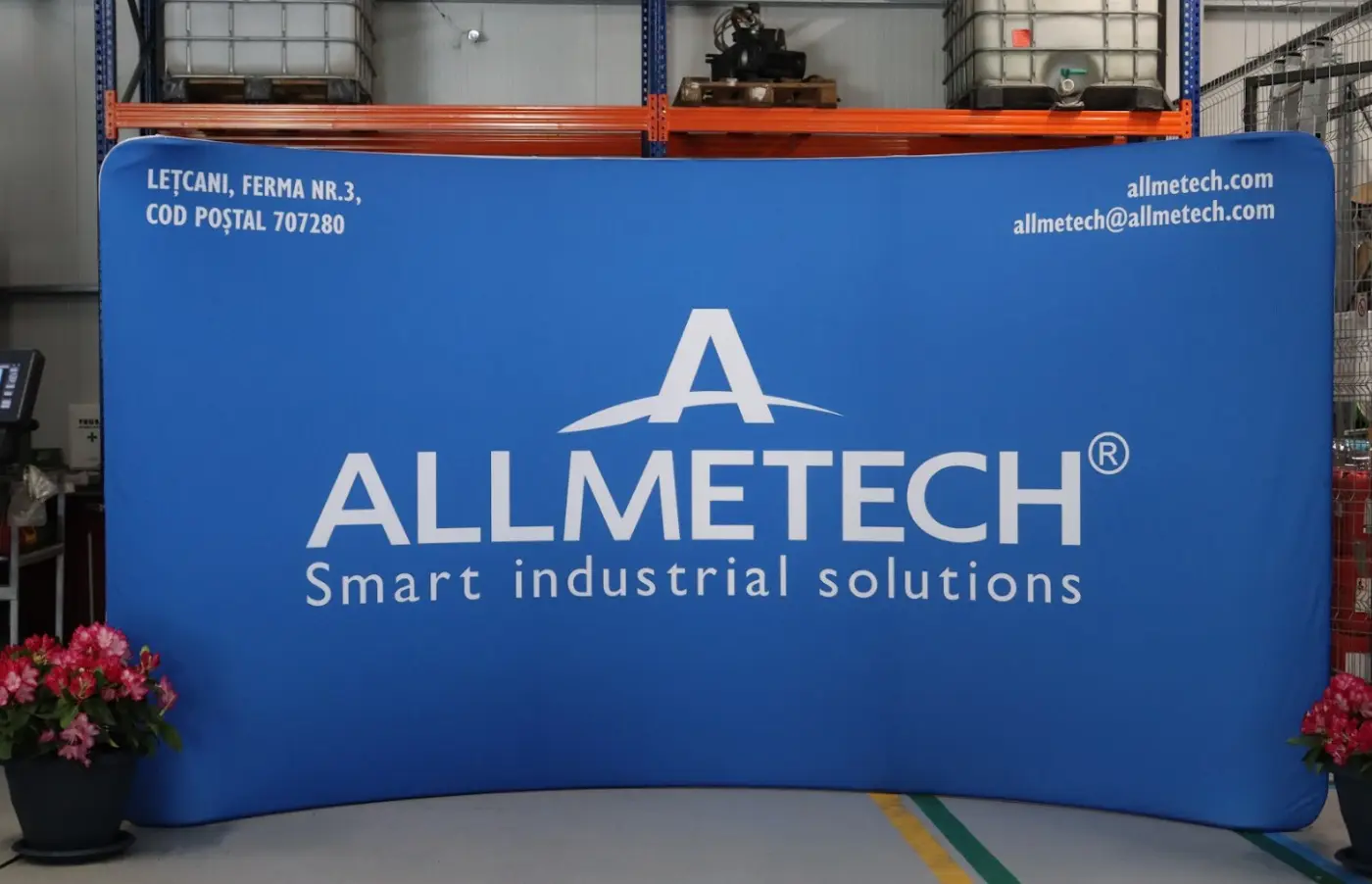 Sistem textil curbat Allmetech, cu grafică albastră, amplasat într-un spațiu industrial.