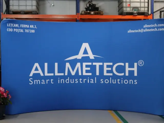 Sistem textil curbat Allmetech, cu grafică albastră, amplasat într-un spațiu industrial.